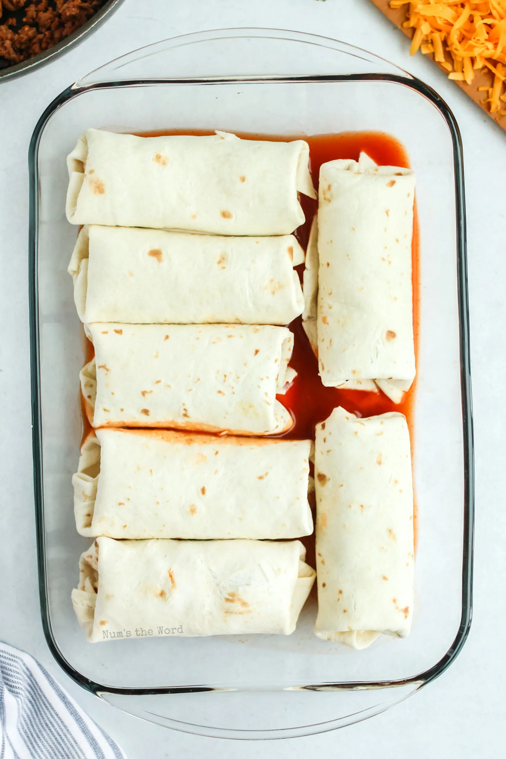 7 wrapped burritos filled and placed in a casserole dish