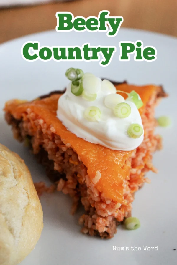 Main image for Beefy Country Pie. A slice of pie on a plate with a roll.