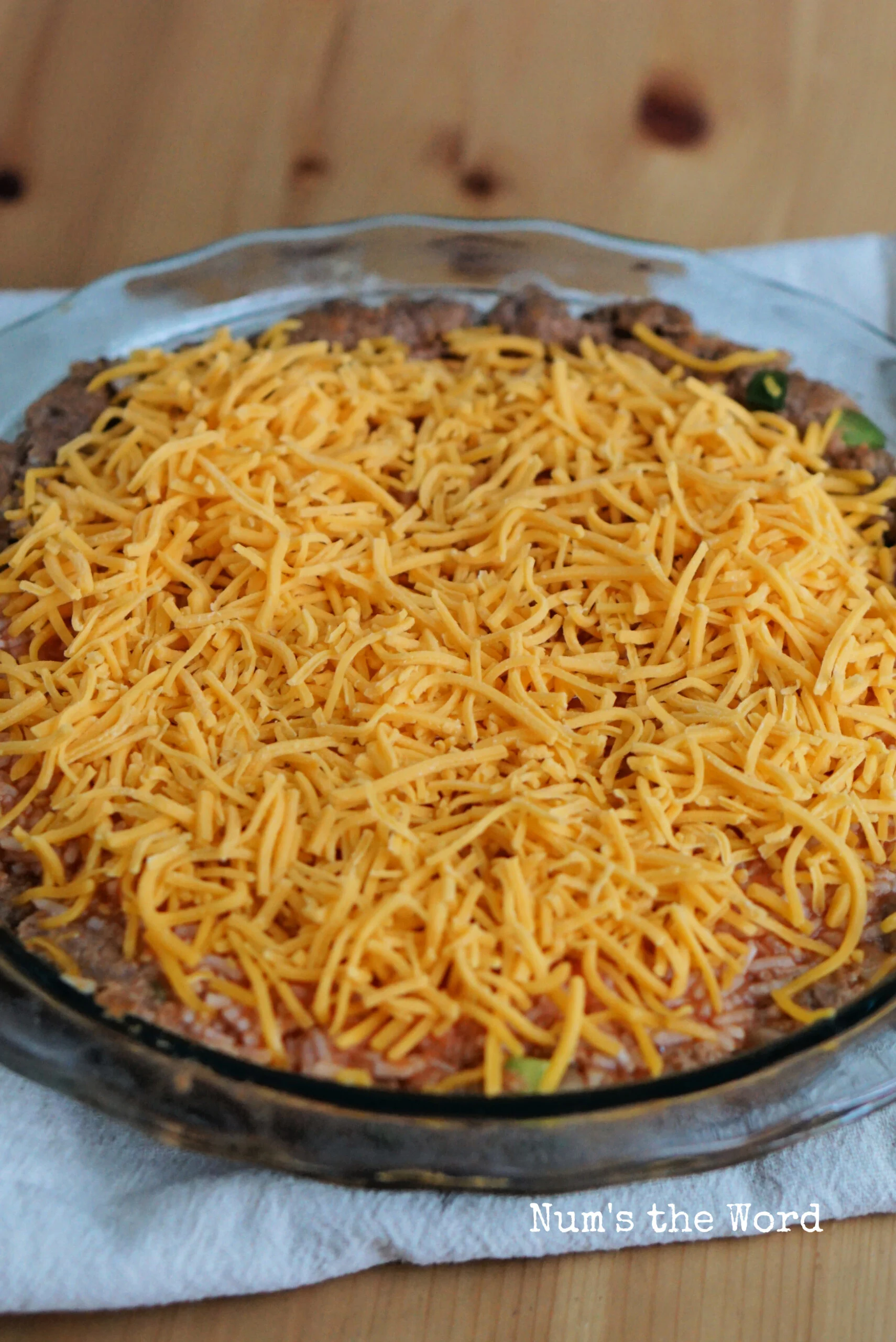 Cheese topping rice mixture in pie plate.