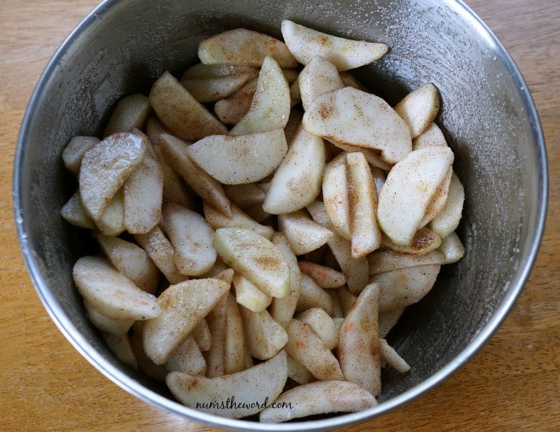 Apple Cobbler Cake - apples and spiced in a bowl all mixed up.