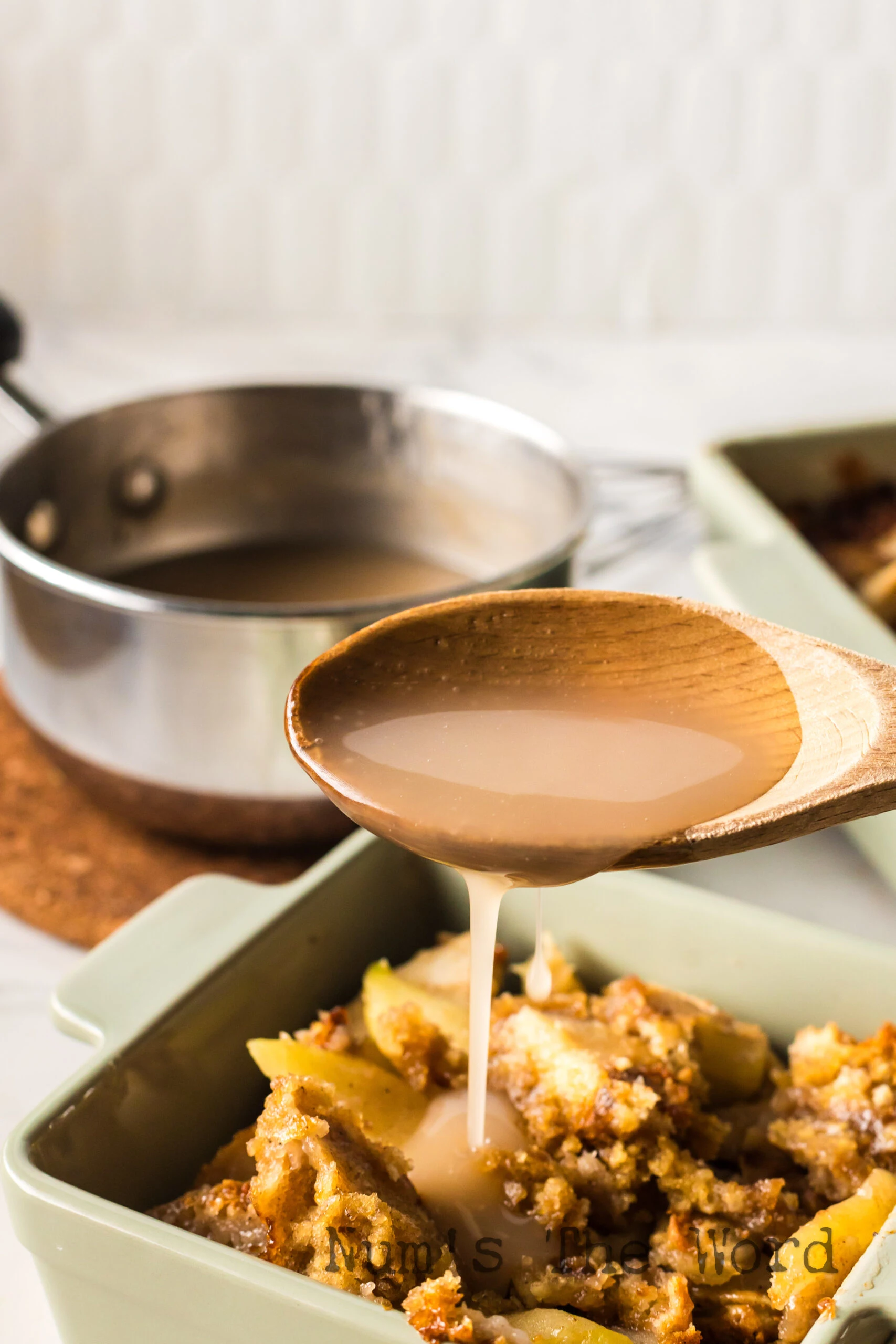Glaze being poured over hot apple cobbler