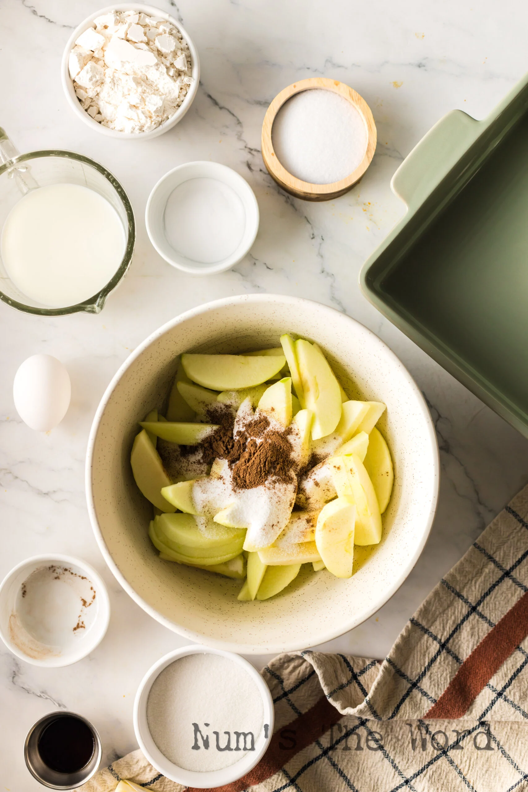 sliced apples in a bowl with sugar and all spice.