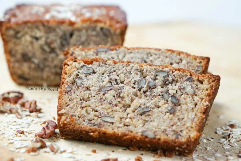 Oatmeal Pecan Banana Bread - Slices of bread close to camera, with loaf in the background.