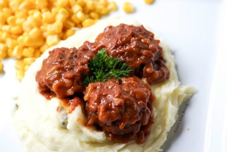 Porcupine Meatballs - Down side angle of plate with meatballs on mashed potatoes with corn on side