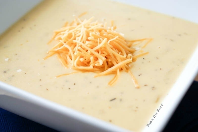 Onion Cheddar Soup - side angle of soup in bowl topped with shredded cheese