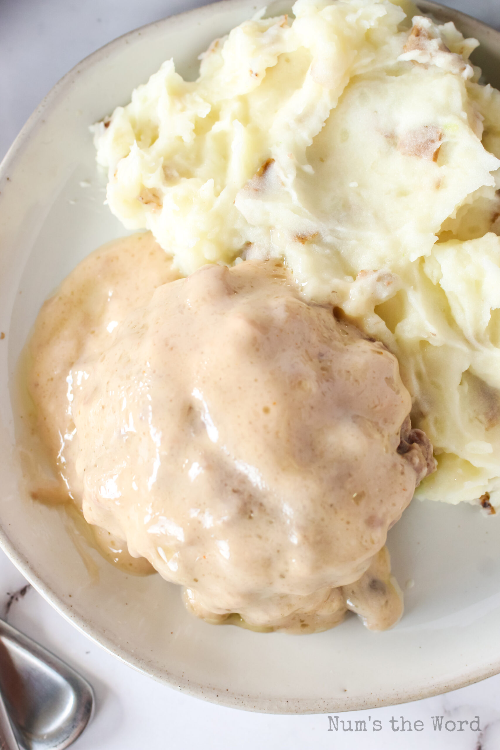 top view of burger with mashed potatoes on a plate, smothered in gravy,.