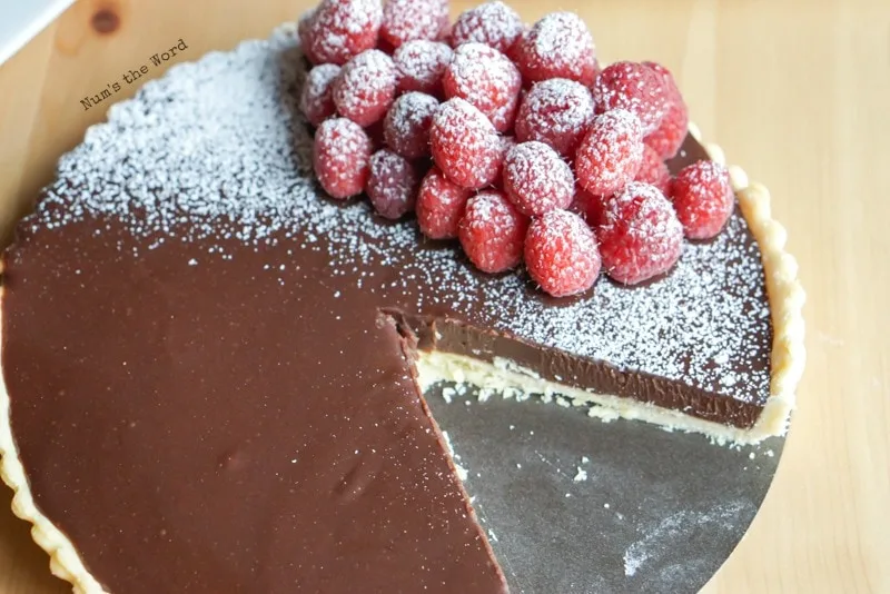 Raspberry Chocolate Tart - tart from down angle with a slice cut out