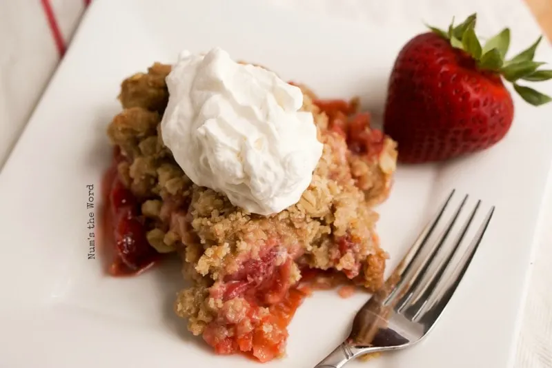 strawberry rhubarb crisp on plate with whipped cream