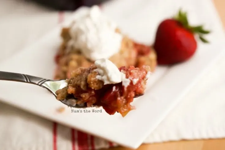 close up of strawberry rhubarb crisp on fork