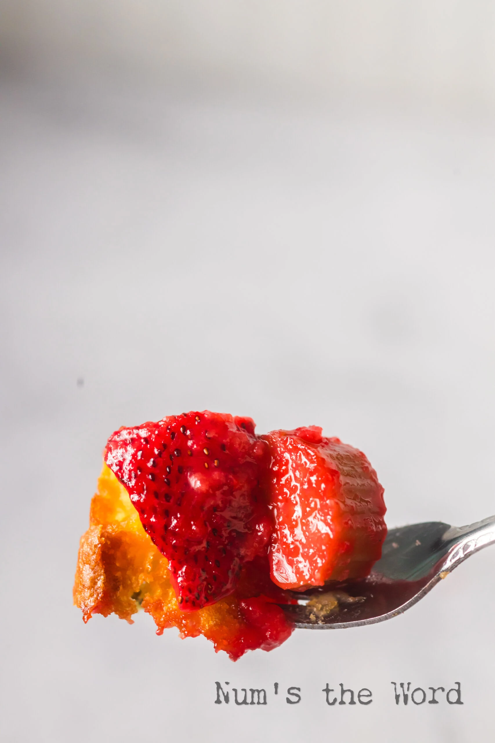fork full of cake, strawberries and rhubarb.