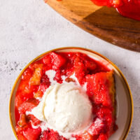 A slice of cake on a plate with a scoop of vanilla ice cream.