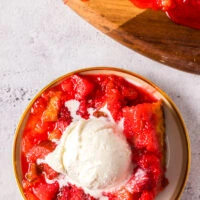 A slice of cake on a plate with a scoop of vanilla ice cream.