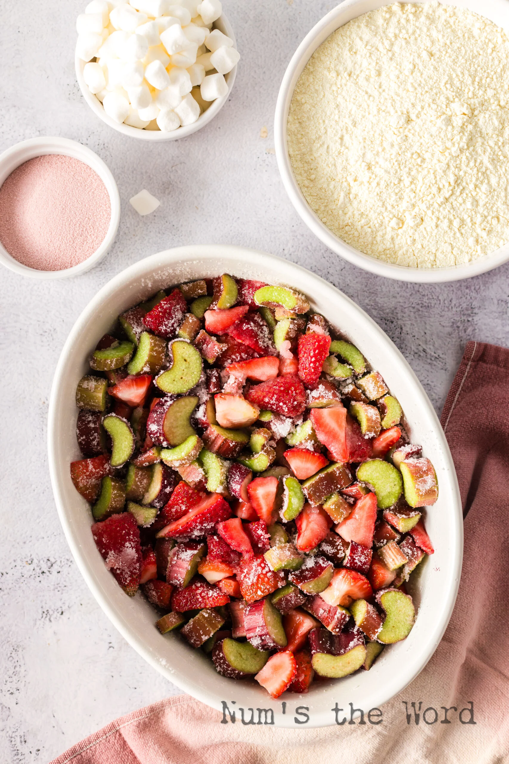 strawberries, rhubarb and sugar mixed in the bottom of a casserole dish.