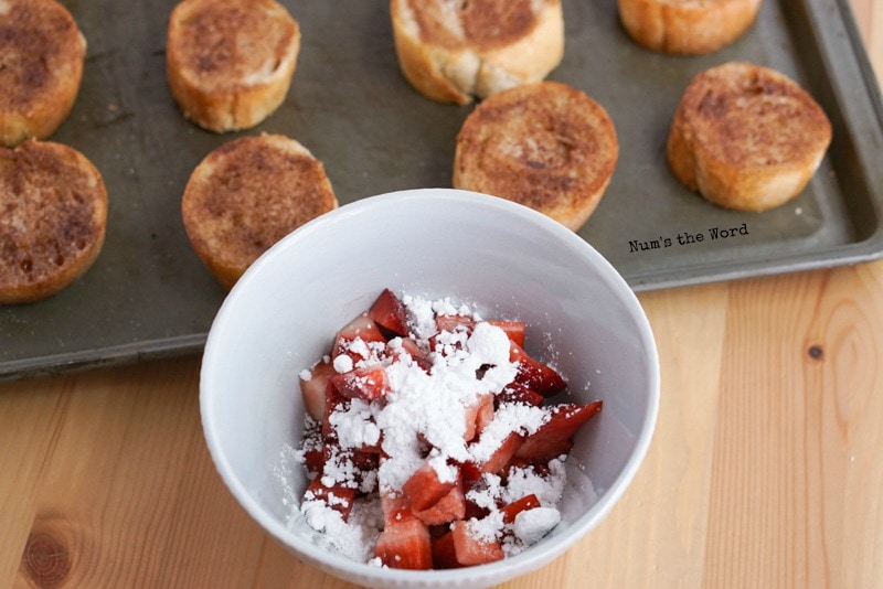 Strawberries & Cream Bruschetta - cooked on pan with bowl of strawberries & powdered sugar in front