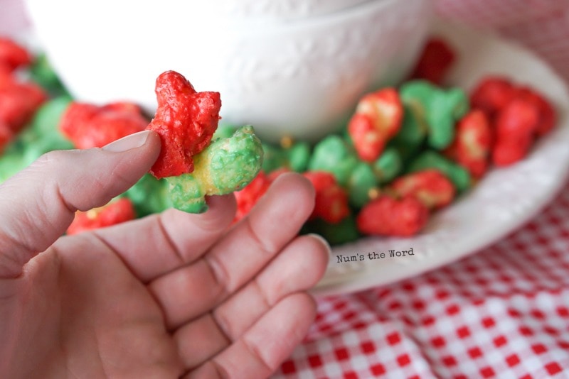 Christmas Puffcorn - red and green nuggest held in hands side by side, different angel