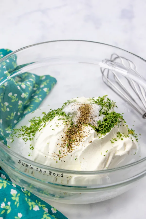 sour cream, salt, vinegar, dill weed, sugar and black pepper in a bowl, unmixed.