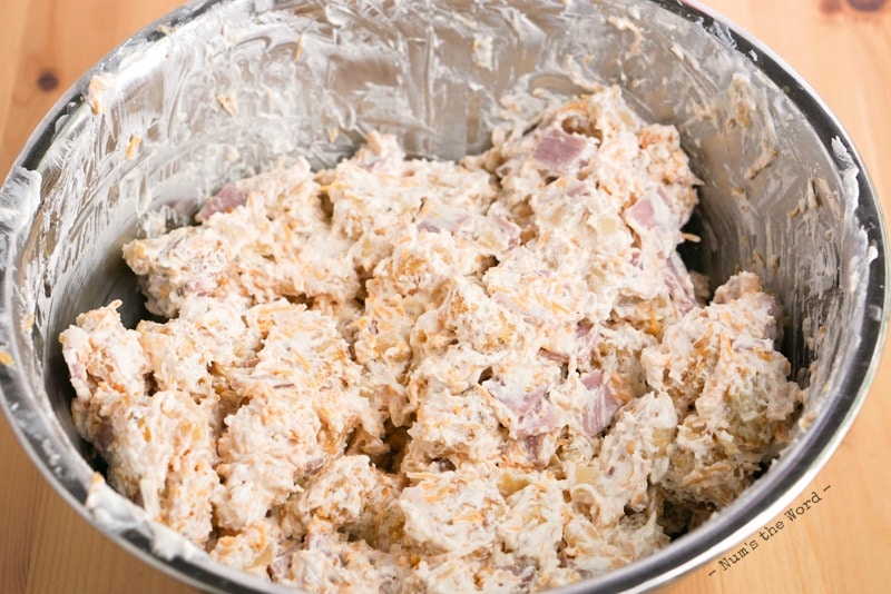 Casserole de petit déjeuner au jambon et aux pommes de terre - grand bol avec tous les ingrédients, sauf le parmesan, mélangés dans un bol