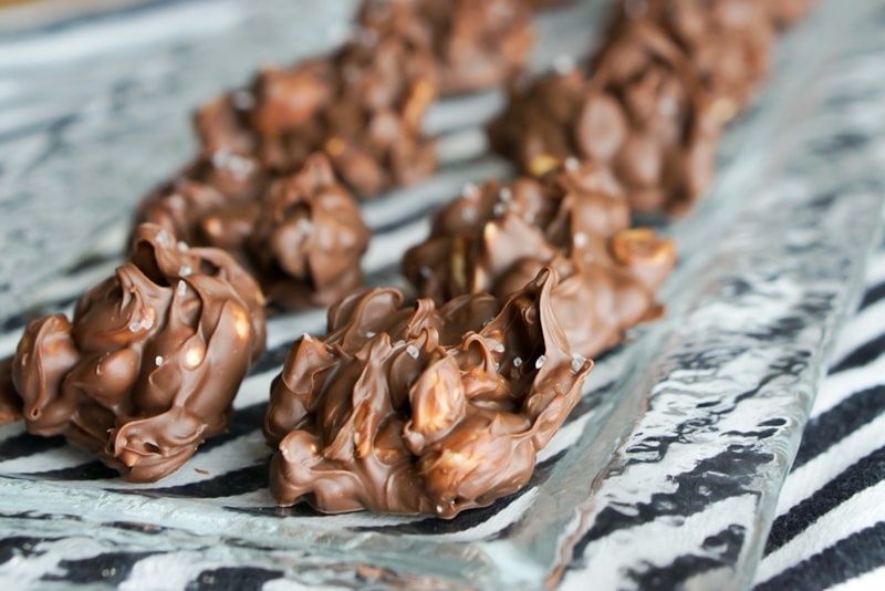 Chocolate Peanut Clusters - on glass platter ready to serve