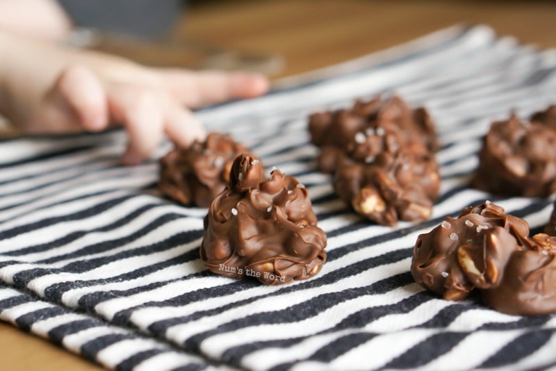 Chocolate Peanut Clusters - photographing chocolate clusters with sons fingers sneaking into photo