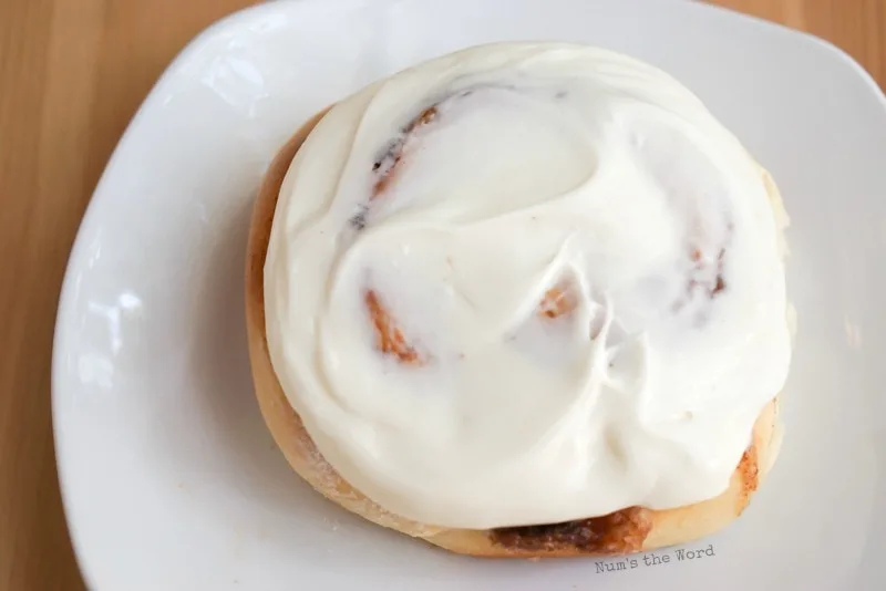 Leftover Mashed Potato Cinnamon Rolls - single cinnamon roll on a plate covered in cream cheese frosting