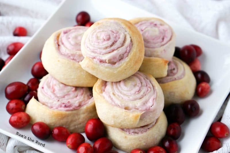 Leftover Cranberry Sauce Roll Ups - different angle of roll ups on plate with cranberries all around