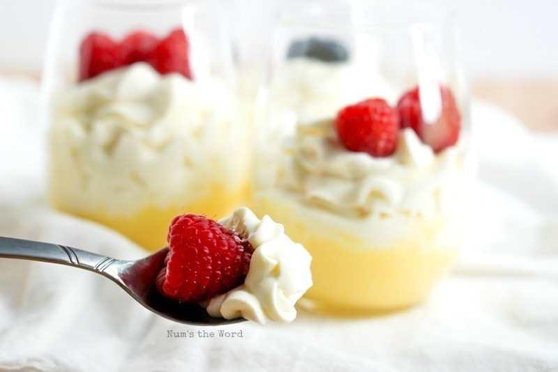 Lemon Curd Mousse on spoon close up with cups of it in background