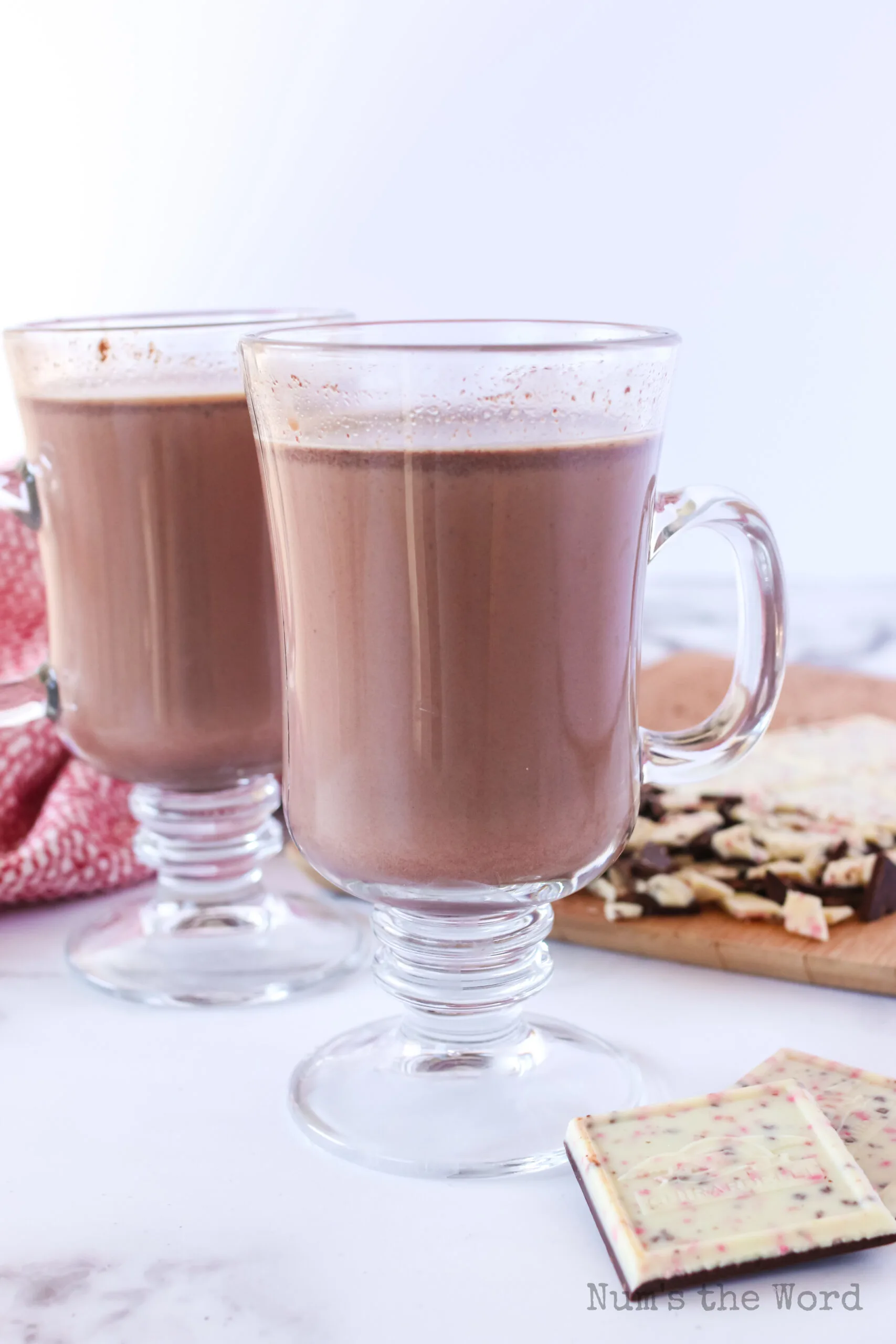 side view of 2 glasses of hot cocoa freshly poured