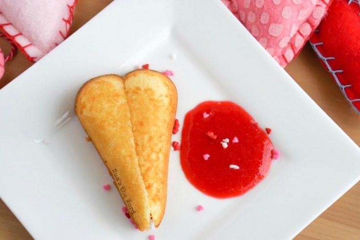 Twinkie Hearts - Twinkie Heart on plage with raspberry puree next to it and sprinkles. Photo taken from above.