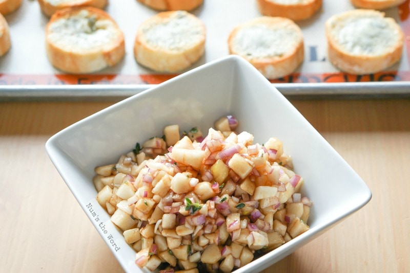 Pear & Proscuitto Bruschetta - Bowl of pear and vinegar mixture with toasted bread bites in the background