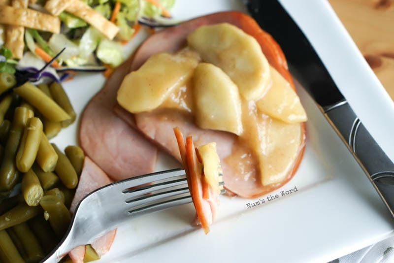 Ham Steaks with Sauteed Apples - fork full of ham and apples resting on plate next to ham steaks.