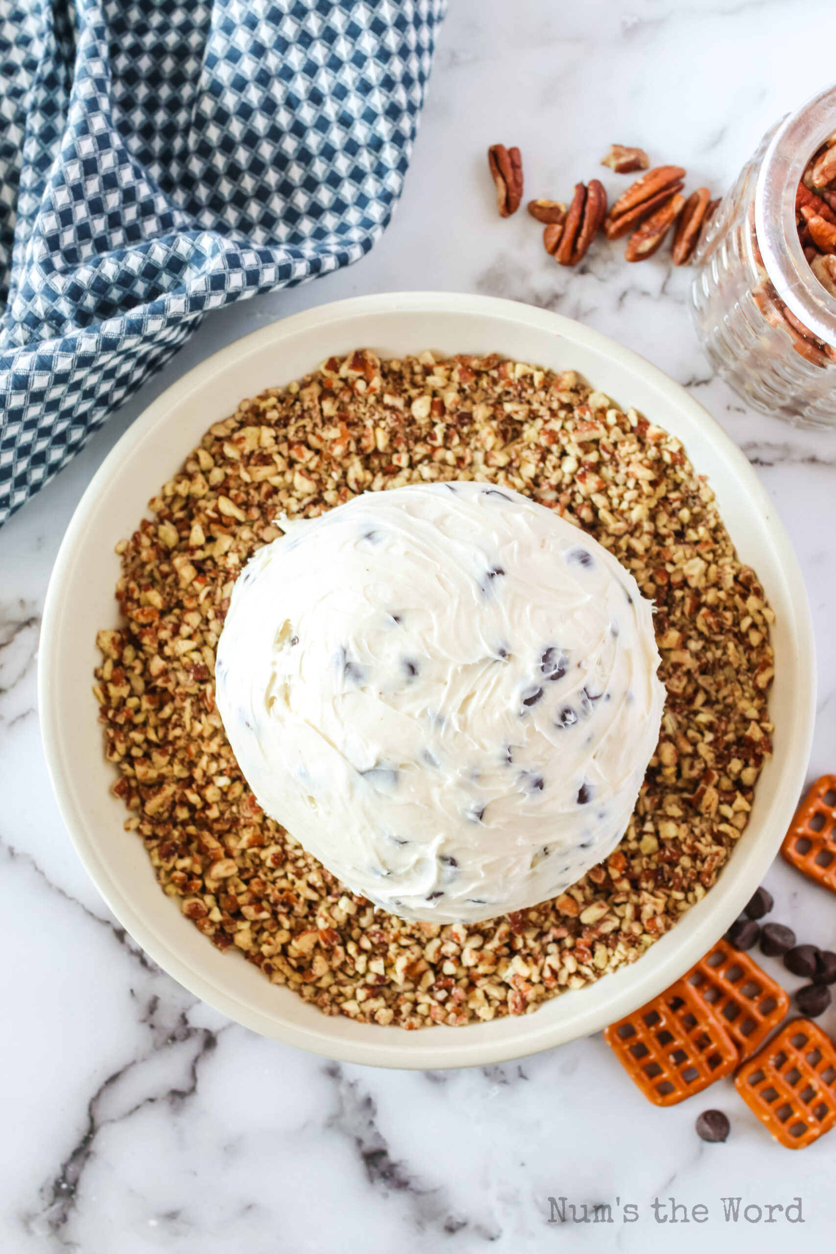 chilled cheese ball in a bowl of chopped pecans.