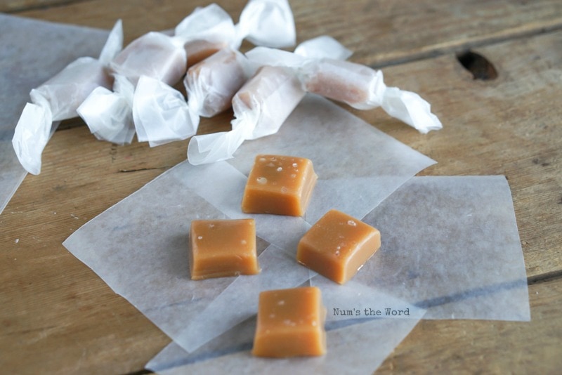 Sea Salt Caramels - top angle of caramels on wax paper ready to be rolled. Already rolled caramels in the background