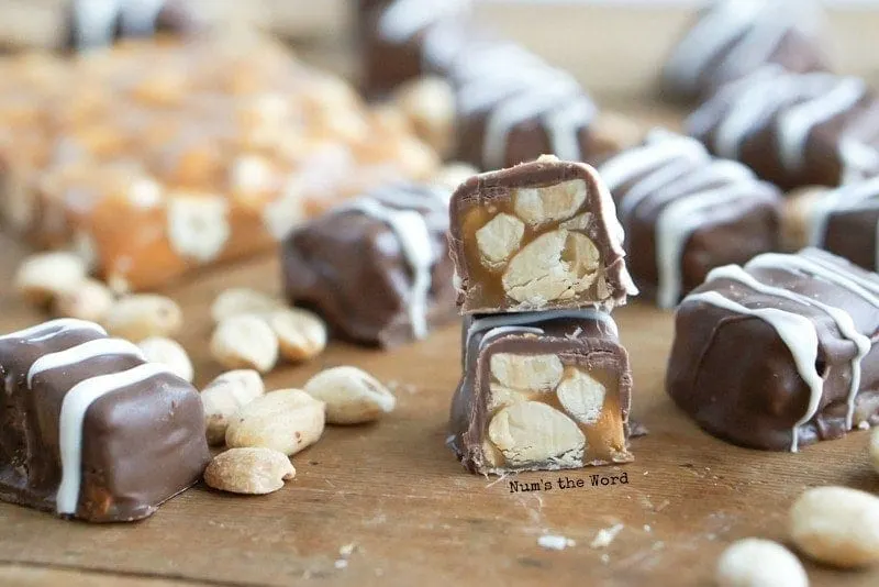 Salted Peanut Caramels - Chocolate covered caramels all over with one cut in half to show insides.