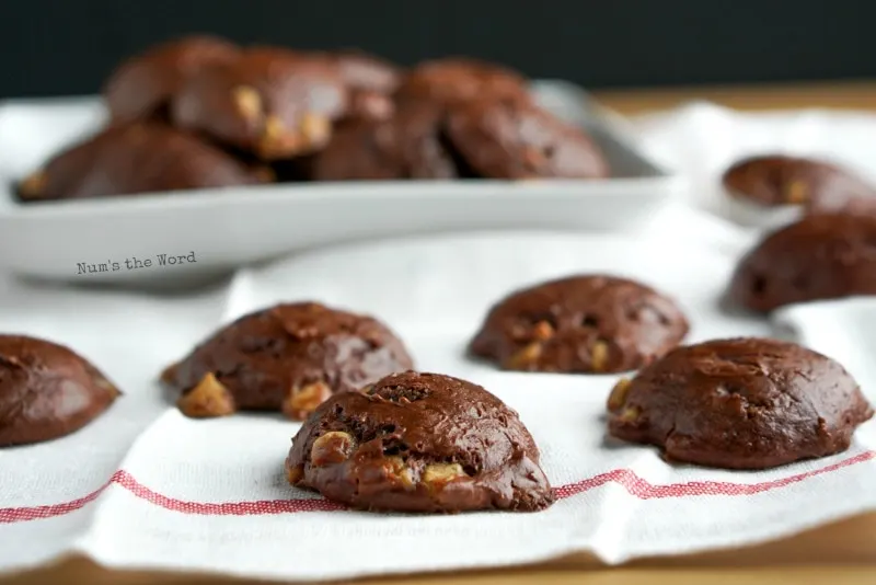 3 Ingredient Chocolate Caramel Cookies - Cookies laid out on a white towel. The plate of cookies in background.
