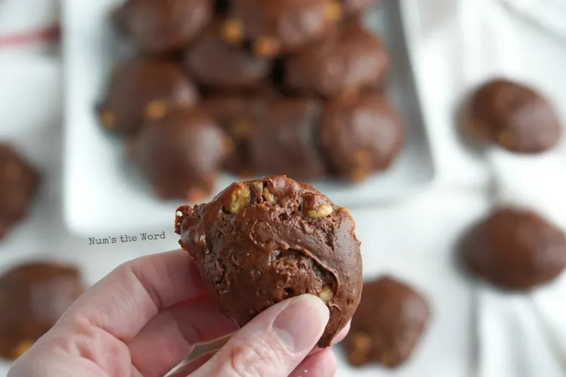 3 Ingredient Chocolate Caramel Cookies - holding a cookie close to camera with plate of cookies in background.