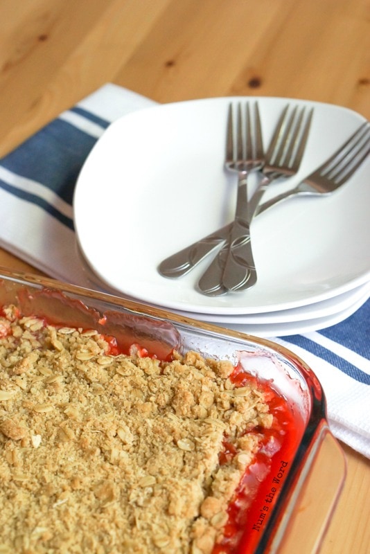 Cherry Rhubarb Crisp - crisp in pan next to plates and forks, ready to be scooped out.