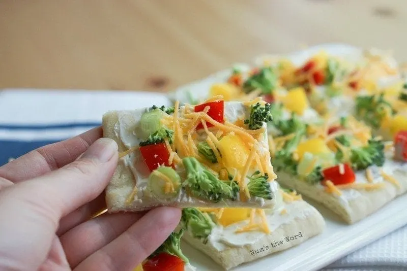 No Bake Veggie Pizza Bites - hand holding up a slice of the pizza