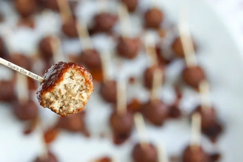 Cranberry Barbecue Meatballs - meatball on a toothpick with a bite taken out of it.