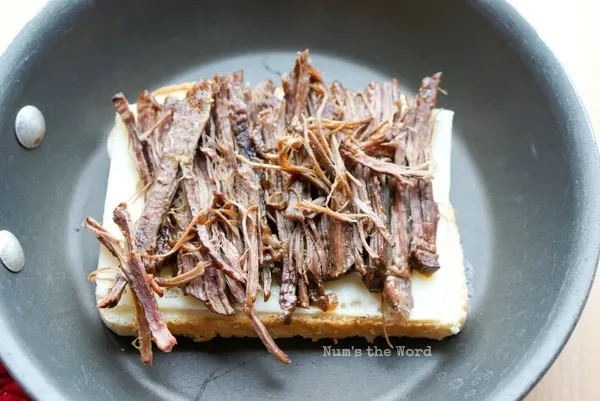 Leftover Pot Roast Grilled Cheese - one slice of cheese and pot roast on top of slice of bread