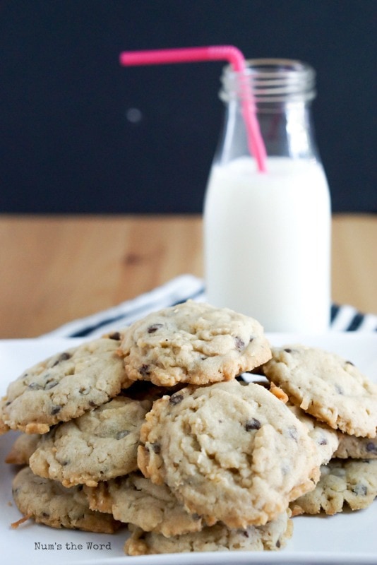 Krispy Coconut Oatmeal Cookies - cookies piled high on a plate with a glass of milk in background