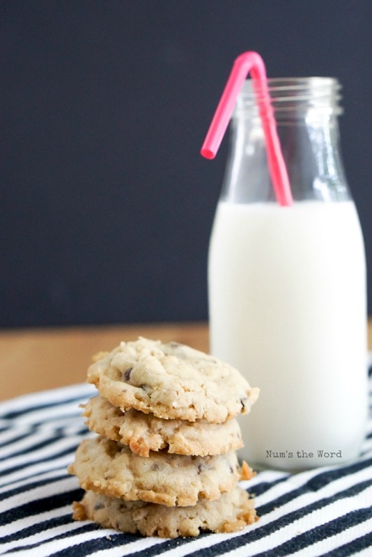 Krispy Coconut Oatmeal Cookies - 3 cookies stacked with glass of milk behind.