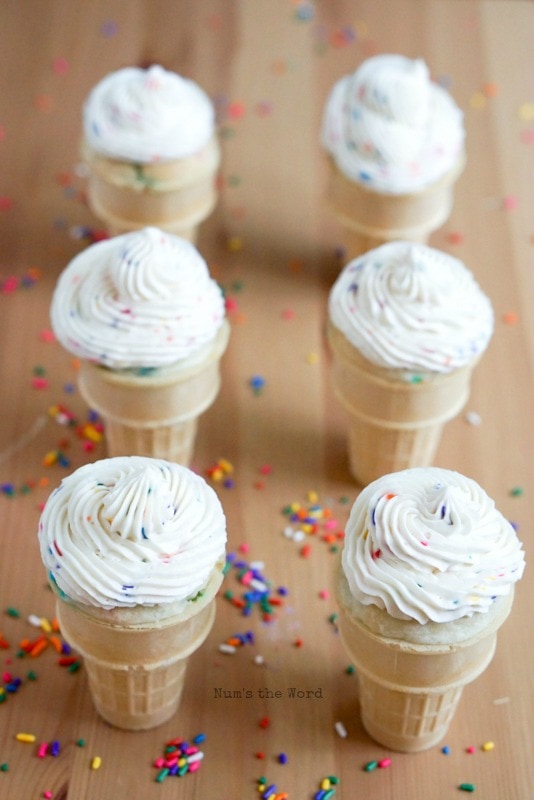 Glaseado de crema de mantequilla Funfetti-cupcakes en un cono de helado cubierto con glaseado