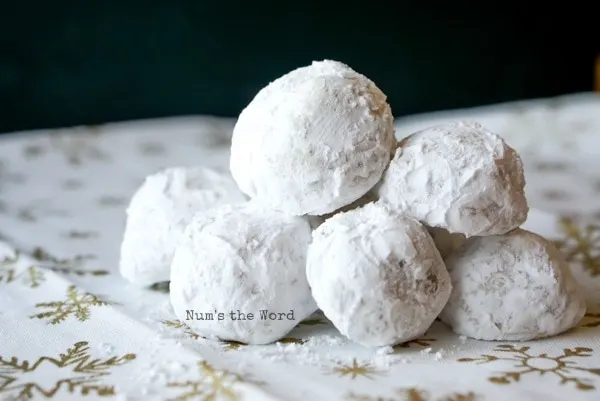 Surprise Snowball Cookies - cookies sitting on a snowflake cloth stacked up on each other.