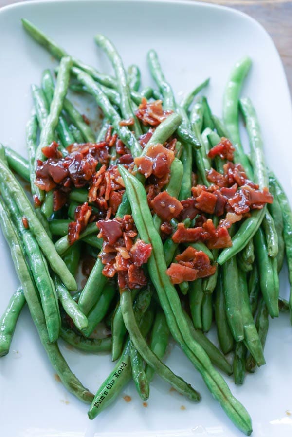 green beans and candied bacon plated up on serving tray.