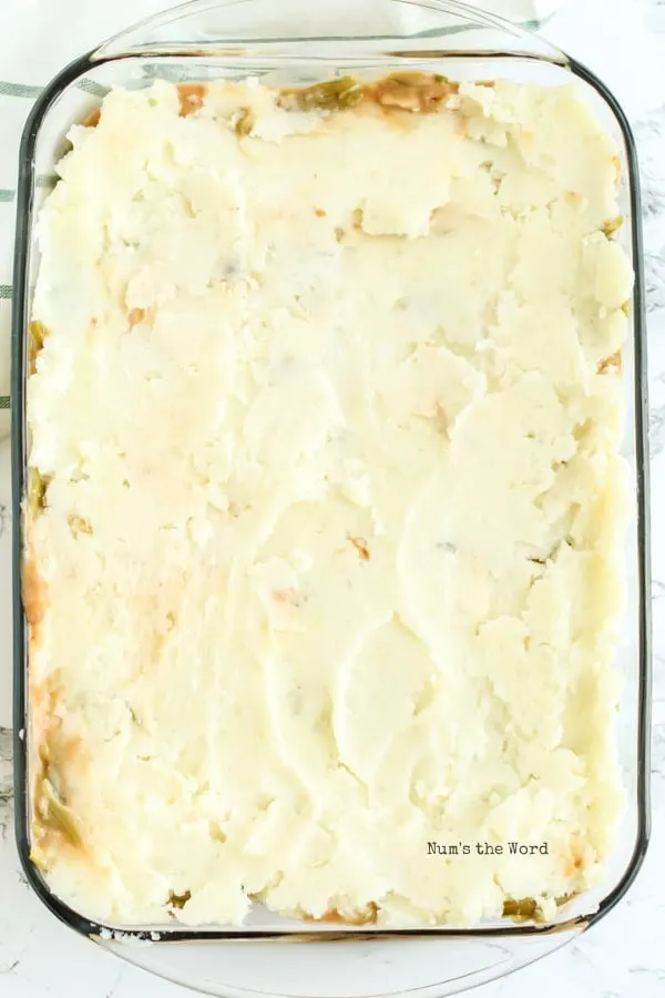 Salisbury Steak Casserole Recipe - mashed potatoes spread over green beans and ready to go into oven.