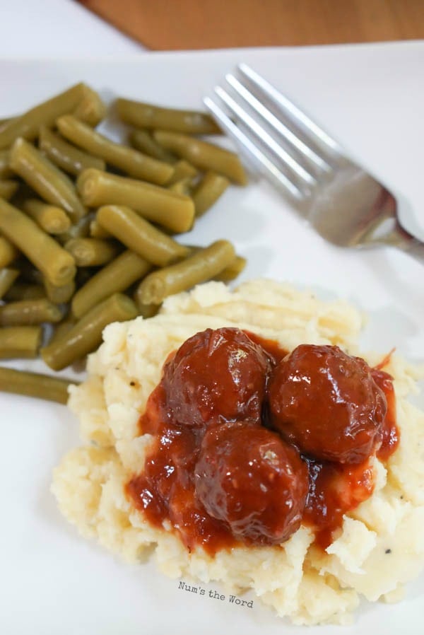 Chili Cranberry Meatballs - meatballs over mashed potatoes on plate with green beans