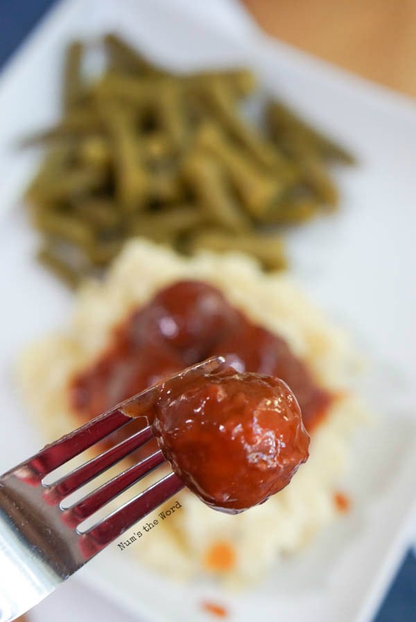 Chili Cranberry Meatballs - fork holding up a single meatball close to camera lens