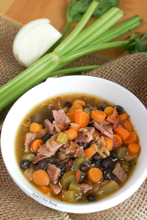 Ham Bone & Vegetable Soup - zoomed out image soup with onion and celery next to 