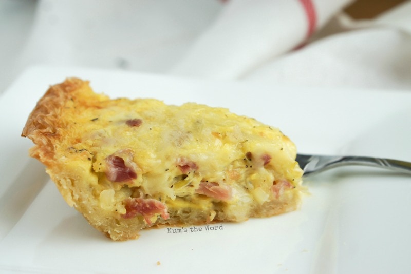 Ham & Cheese Quiche - slice of quiche on a plate, side view.