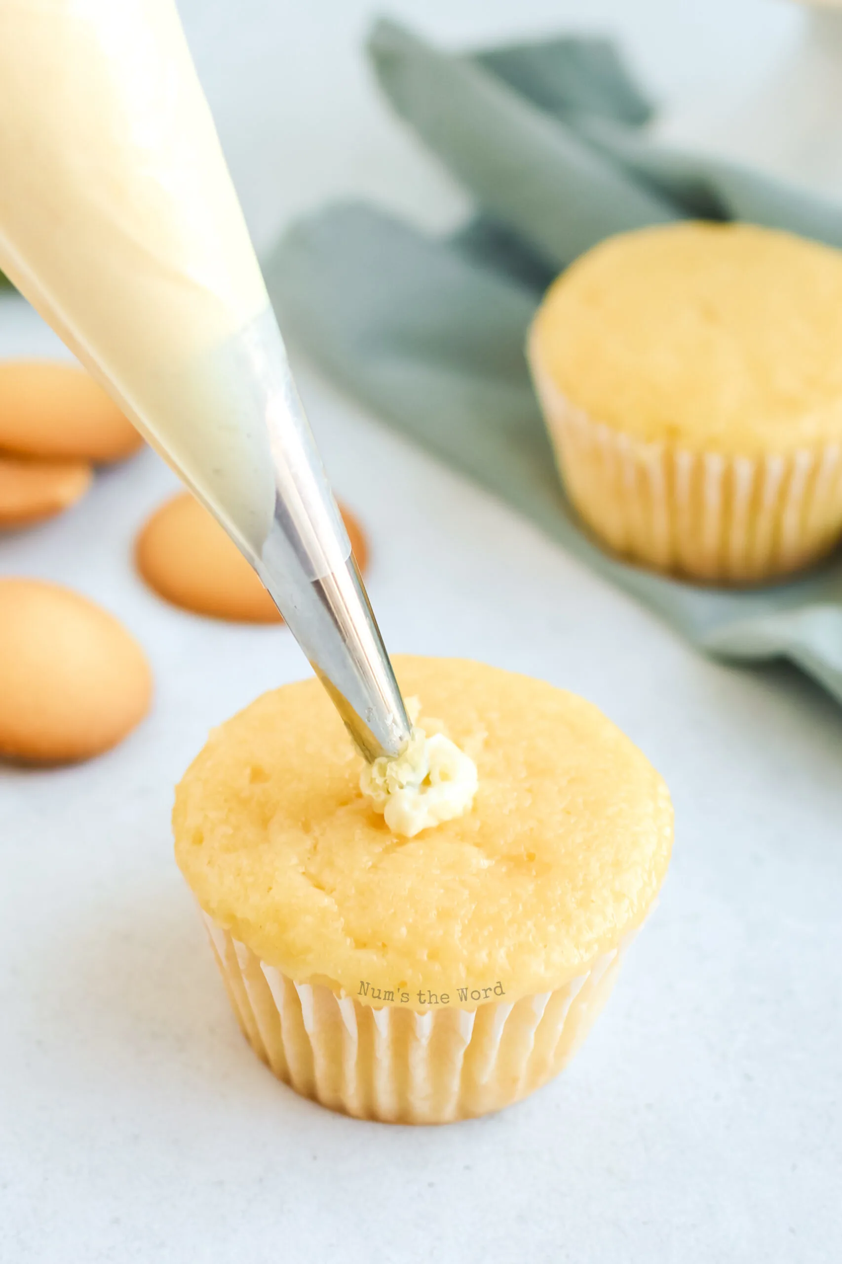 piping bag filled with banana pudding filling cupcakes.